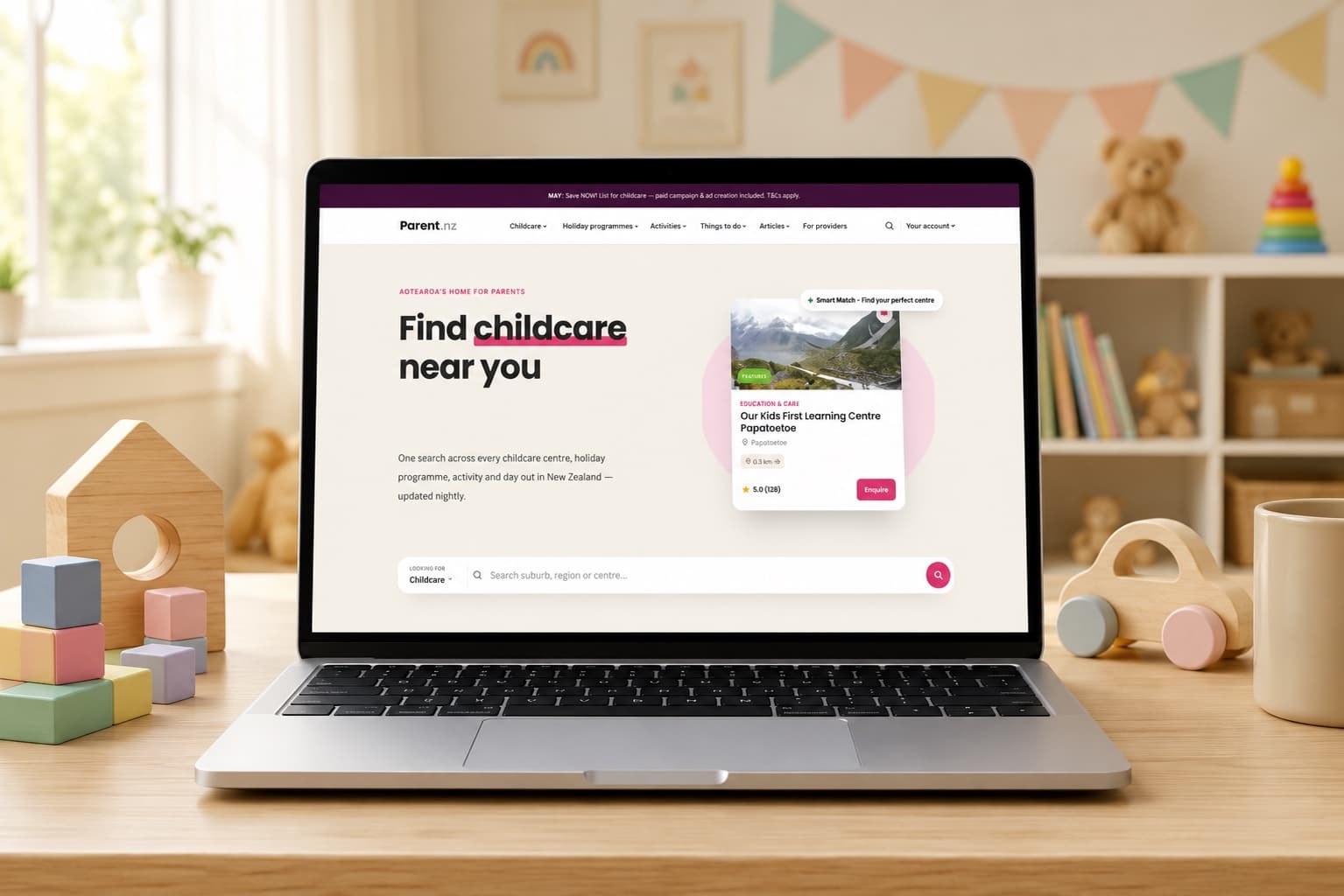 The Parent.nz homepage on a laptop in a playroom: Find childcare near you, one search bar, and a Smart Match centre card